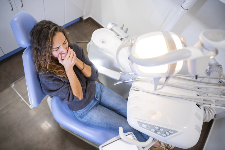 Young female patient frightened at the dental clinic