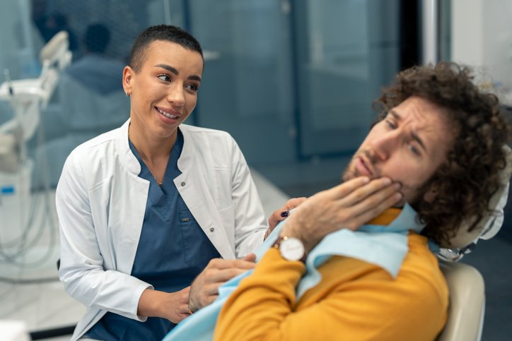 dentist comforting depressed male patient